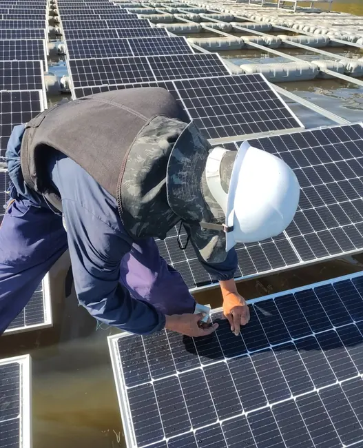 Profissional com capacete fixando módulos solares