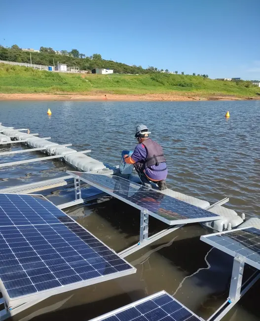 Profissional montando módulos solares em estrutura sobre a água